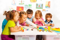 Group of happy kids painting and